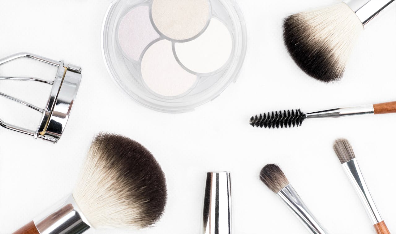Home Flat lay of various makeup brushes and tools on a white background.